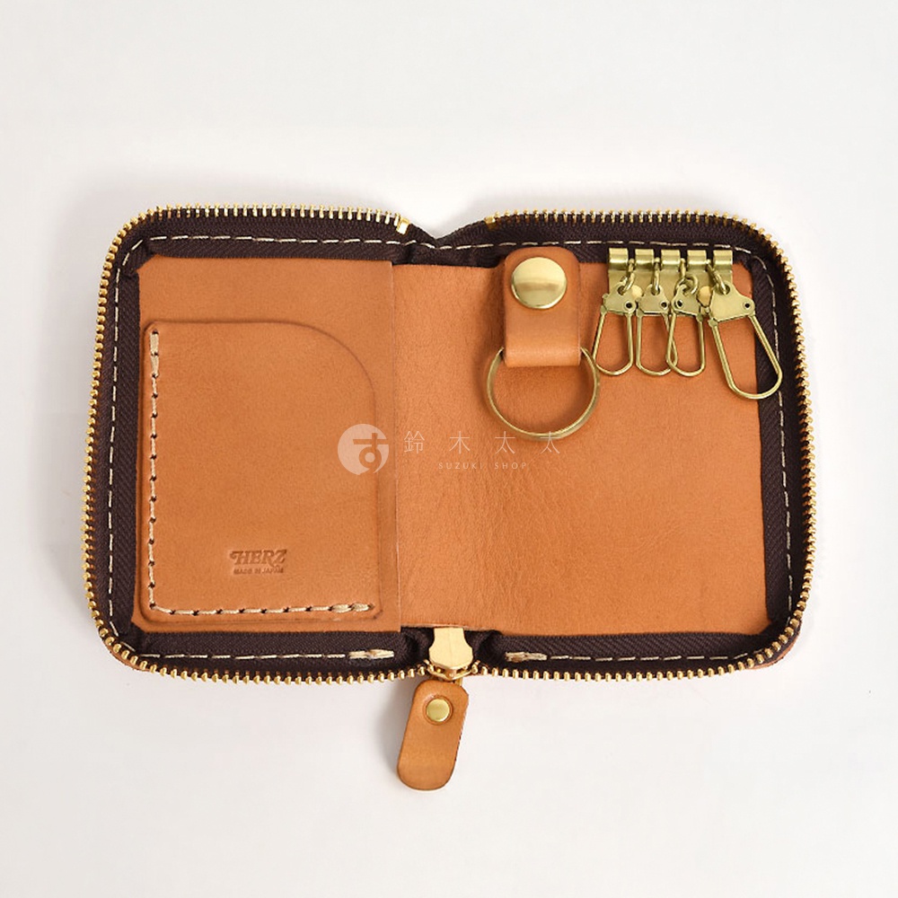 開放式的棕色皮革鑰匙包，內有卡槽和四個金屬掛鉤，拉鍊為金色。