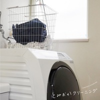 不鏽鋼網格收納籃裝有深藍色衣物和白色衣物，籃子放在白色洗衣機頂部，背景是窗戶。