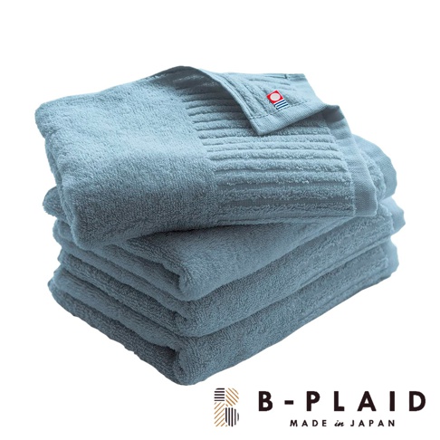 一疊淺藍色、觸感柔暖的長毛浴巾，帶有直紋織紋和品牌標誌。