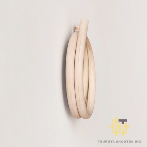 淺木色藤編材質製成的圓形鏡子，藤編線條彎曲纏繞，形成獨特的造型。