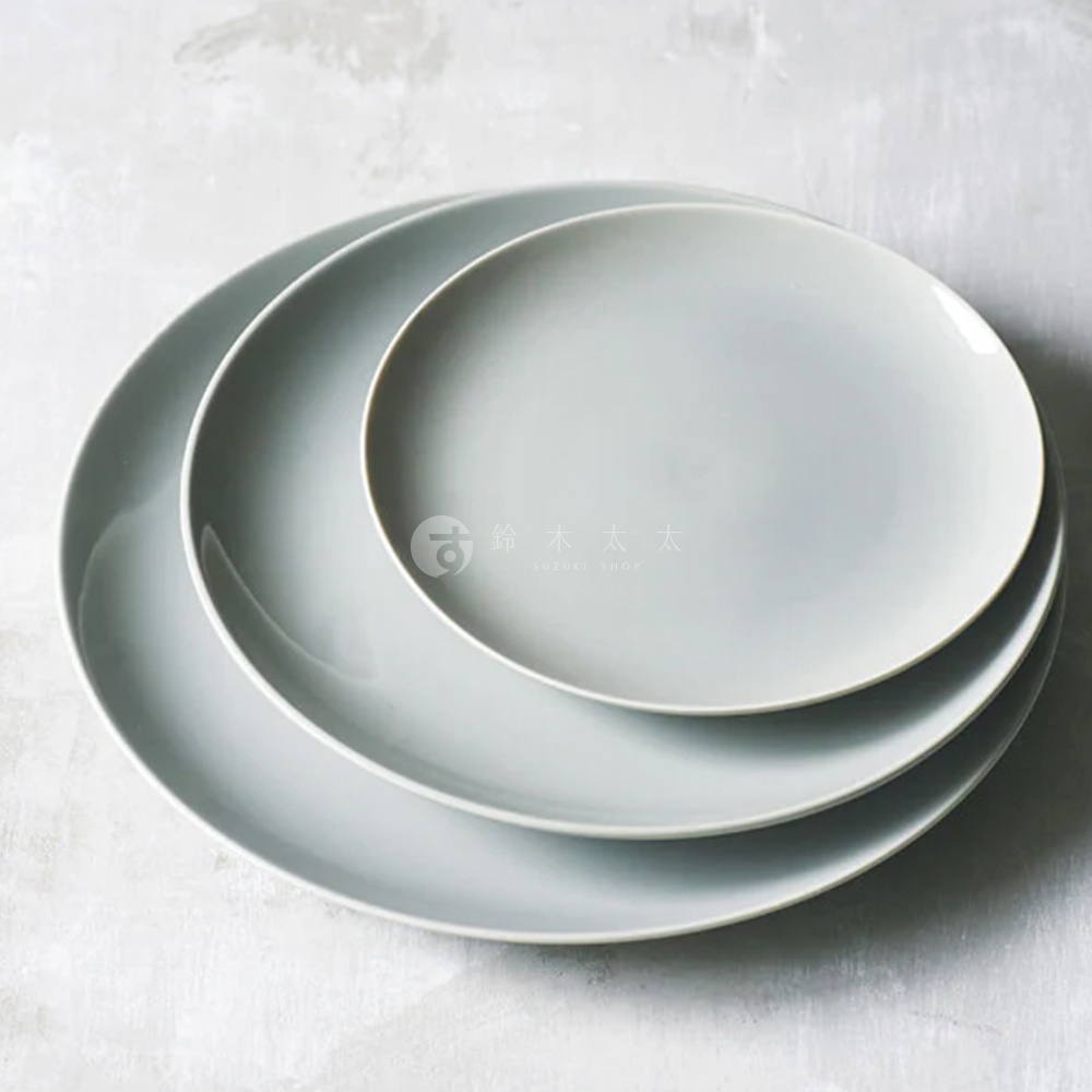 Aito 美濃燒簡約素雅質感圓餐盤6入組，共疊放三件，左側盤子最大，疊在最下層，中間盤子居中，最上面是最小的盤子，盤子呈現淺灰藍色調，背景為灰白紋理水泥地面。