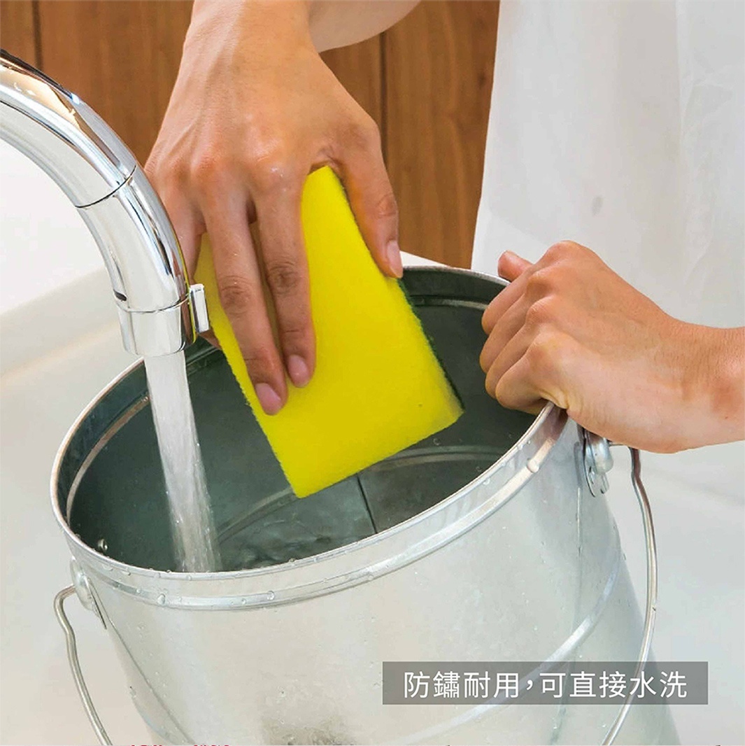 雙手正在水龍頭下用黃色海綿清洗銀色水桶，水桶上飾有防鏽耐用，可直接水洗的文字。
