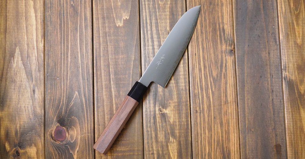 [景清] Chromax鋼三德刀，18公分刀刃，搭配八角形胡桃木手柄，刀身上有細緻的壓紋和日文刻字。