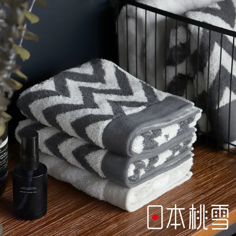 今治北歐毛巾，以白色和灰色相間的鋸齒狀圖案為主，觸感柔軟，材質為純棉，另有一條灰色滾邊。