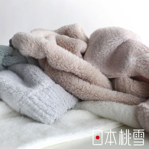 日本桃雪品牌浴巾，蓬鬆柔軟的淺粉色、灰藍色和白色毛巾疊放，營造溫馨舒適的視覺感受。