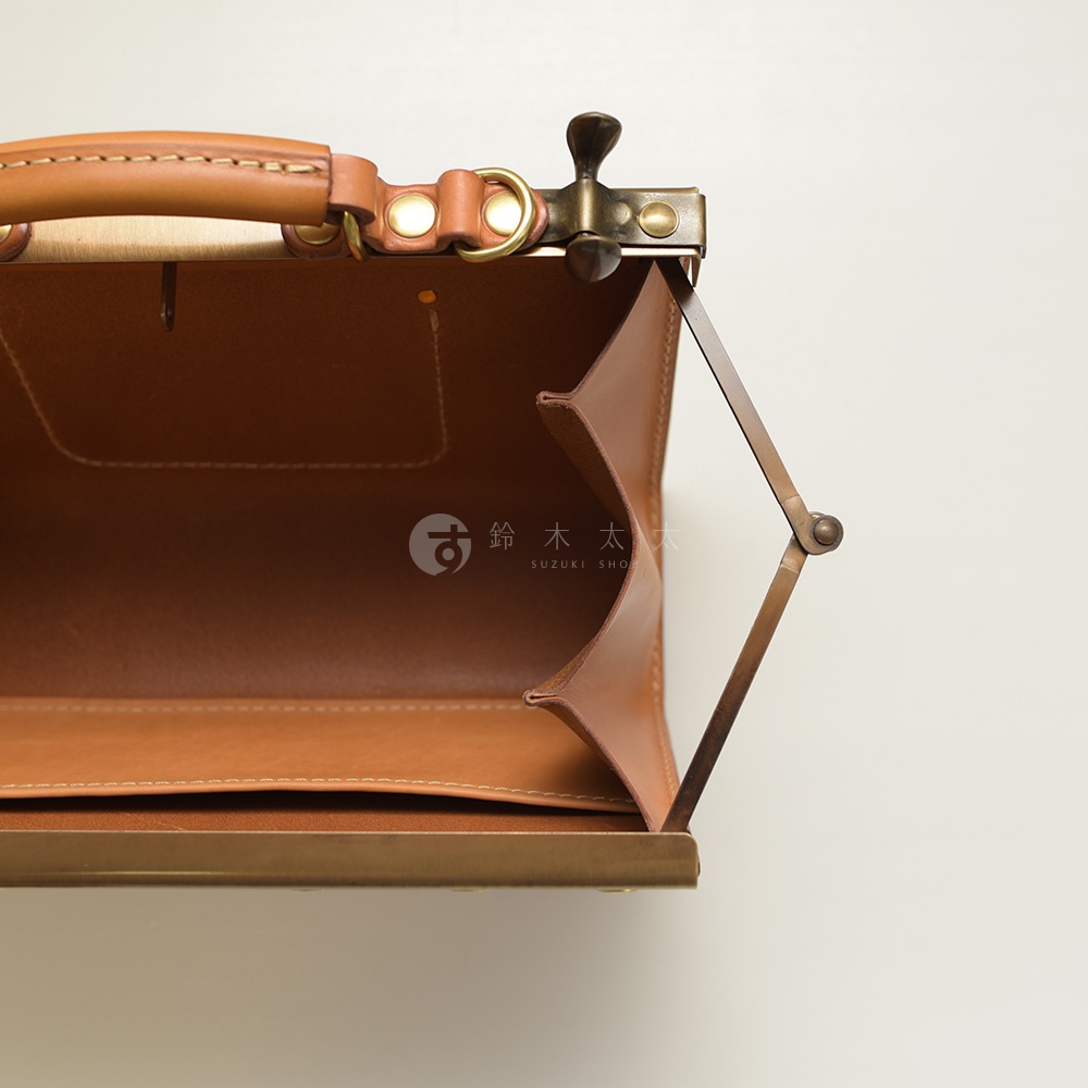 職人手作皮革復古口金兩用手提包，展示包款內部，淺棕色皮革，搭配復古金屬開合結構與提把。