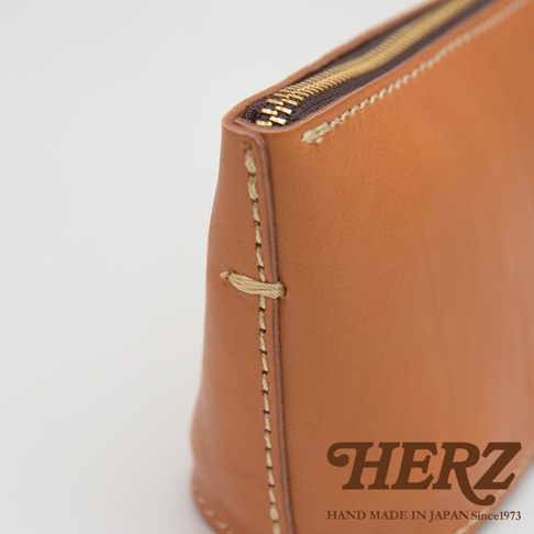 職人手作皮革三角收納包，淺棕色皮革，手工縫線，金色拉鍊。