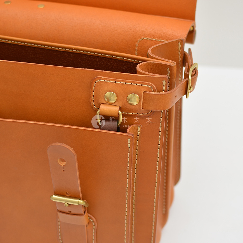 職人手作皮革旅行包 A-102，焦糖色牛皮材質，雙扣環設計，側邊有精緻縫線細節。