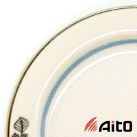 米色陶瓷甜點盤，盤緣有深淺藍色漸層條紋，盤面左下角有壓印的葉紋圖案，邊緣有細緻的線條裝飾。