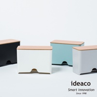 展示四個不同顏色的原木蓋口罩收納抽取盒，包括黑色、白色、淺藍色和灰色。每個收納盒都帶有淺木色的頂蓋，側面下方設有弧形開口。