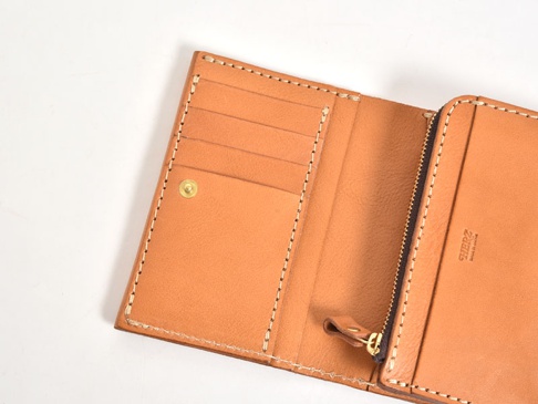 職人手作皮革中型雙折短夾，淺棕色皮革，內部有多個卡槽與零錢袋，以對比色縫線手工車縫，並設有拉鍊開合。