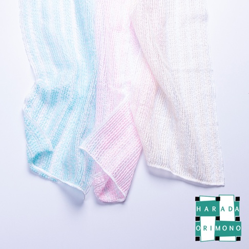 三條蓬鬆的泡泡洗澡巾，分別為淺藍色、粉紅色和白色，材質輕盈，紋理細緻，呈現柔和的漸層色彩。