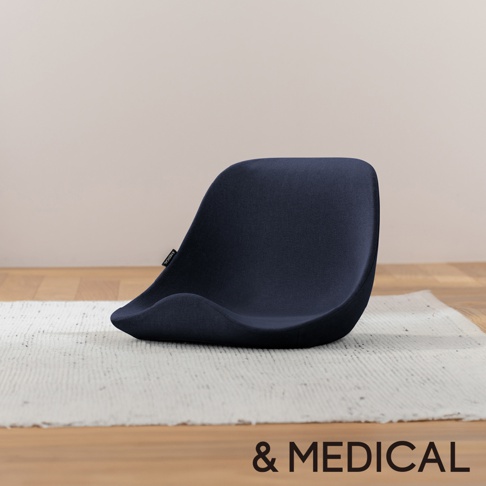 深藍色舒腰正姿座墊，高背設計，布質表面，放在白色紋理地毯上，背景為淺米色牆面和木質地板。