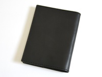 黑色職人手作厚革書套，閉合狀態，展示皮革紋理與車縫細節，風格簡約。