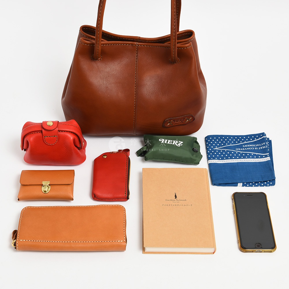 日本HERZ職人手作棕色皮革托特包，搭配同色系錢包、鑰匙包、筆記本，綠色環保袋，藍色印花手帕及手機。