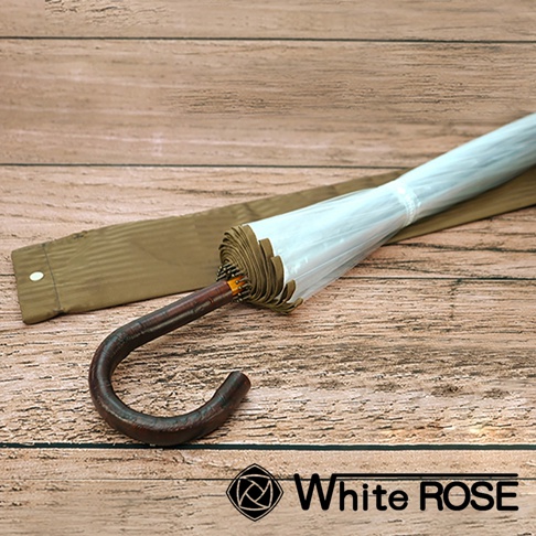 職人高級樺木透明傘，傘骨與傘面閉合，呈現半透明白色。傘柄為深棕色彎曲造型，材質紋理清晰。傘旁配有同色系長形傘套。