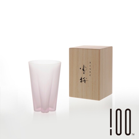 粉色漸層的玻璃杯，杯身呈細長錐形，底部有三瓣花狀設計。一旁擺放著木質包裝盒，盒面印有黑色日文書法字體。