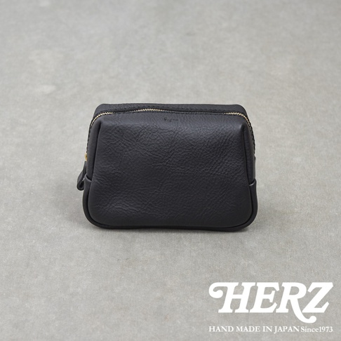 一個日本HERZ職人手作的黑色皮革拉鍊收納包，表面呈現自然的皮革紋理，上方印有Organ品牌字樣，整體造型簡約且具備良好的立體感。