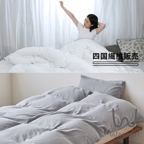日本雙人寢具，白色蓬鬆被子與灰色床鋪，有日文文字「四國纖維販売」。