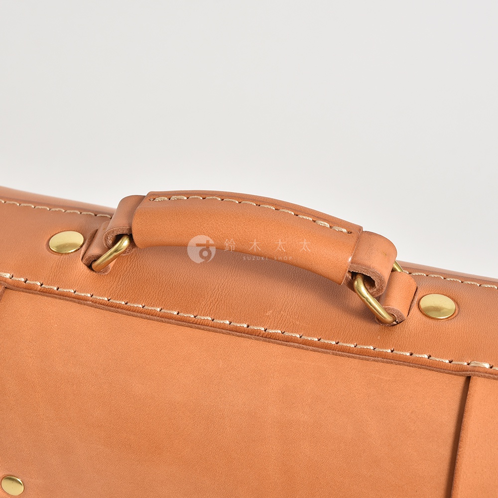 職人手作皮革學院風三用迷你後背包 BC-5 (共5色) 的特寫，展示了其皮革手把、車縫線及金屬铆釘細節，皮革顏色為自然的棕褐色。