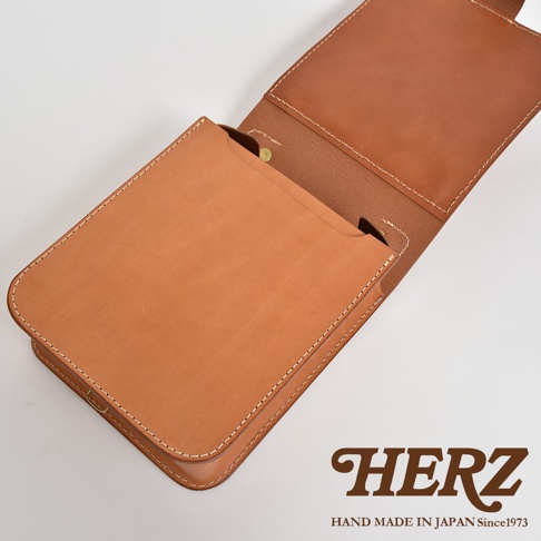 職人手作皮革立體口袋兩用單肩包，採用棕褐色皮革製成，縫線整齊，包身側面可見立體口袋設計，內部結構清晰。