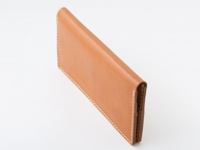 職人手作皮革簡約輕薄扁長夾，以天然皮革製成，呈現溫潤的淺棕色調，邊緣縫線清晰，設計簡潔俐落。