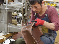 職人手作皮革屋瓦風迷你後背包，使用棕色皮革，於工業縫紉機上製作，皮革上裝有金屬卯釘。