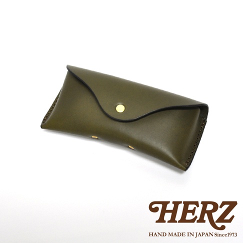 一個橄欖綠色的皮革眼鏡盒，配有金色按鈕和縫線細節，背景為白色。