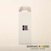 白色紙盒包裝，正面有黑色線條組成的圖案及紅色小印章。盒頂有提把。底部有「SHIRAKI KOUGEI Lantern Craft」字樣。