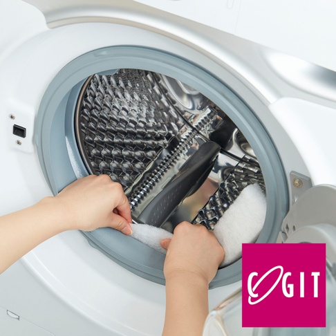 一雙手正將白色、柔軟的清潔條塞入滾筒洗衣機的門縫橡膠圈內，展示產品的清潔用途。