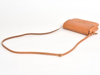 職人手作皮革直式隨行袋，淺棕色，簡約設計，搭配可調節長度的細皮革背帶，整體呈現自然質感。