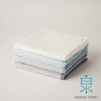 YUKINONE 雪之音柔織有機棉浴巾疊放展示，包含白色、淺藍、藍色和深藍色四種顏色。浴巾材質柔軟，織紋細緻，角落處有品牌標誌。