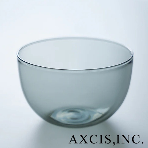 一個光滑的淺灰色玻璃碗，底部有圓形紋路，碗口邊緣有細微的銀色勾勒，整體呈圓潤的半球形。