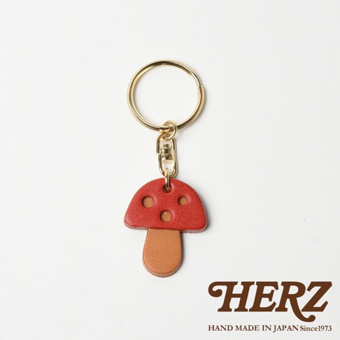 職人手作皮革香菇造型鑰匙圈，菌蓋為紅色，菌柄為棕色，搭配金色鑰匙圈。