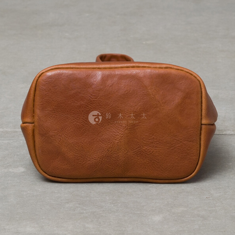 棕色皮革手提包底部，帶有單柄，表面有細緻的紋理。