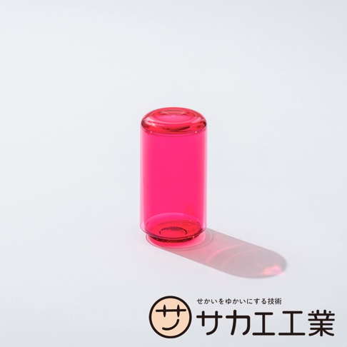 SAKAE 標誌和日文文字，以及一個明亮的粉紅色杯子，在白色背景上投下陰影。