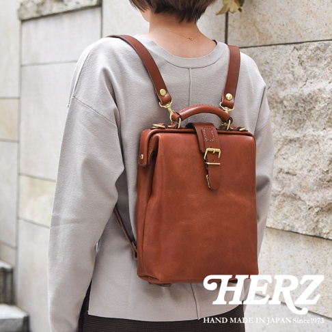 職人手作皮革迷你軟皮杜勒斯包，採用溫暖的棕褐色皮革，搭配金屬扣環和可調節肩帶，造型復古精緻，適合日常攜帶。