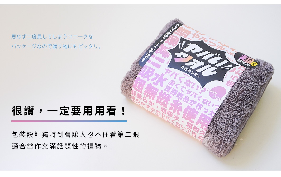 一張深灰色毛巾，覆蓋著色彩繽紛的日文包裝紙，包裝紙上有「SUPER ZERO」和「YABAI」等字樣。