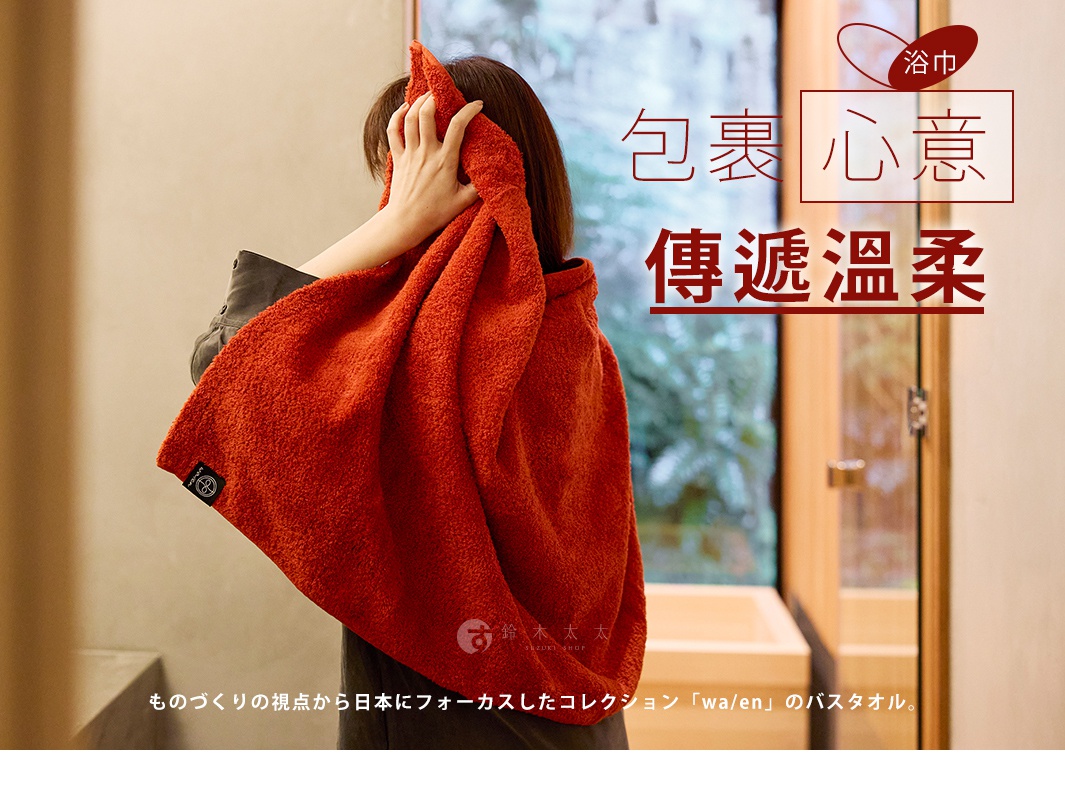 一位女性用橘紅色浴巾擦拭頭部，浴巾上有日文的「包裹心意 傳遞溫柔」字樣。