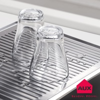 不鏽鋼瀝水盤上放置兩只透明玻璃杯，瀝水盤有條狀紋路，盤面上散落著水滴。