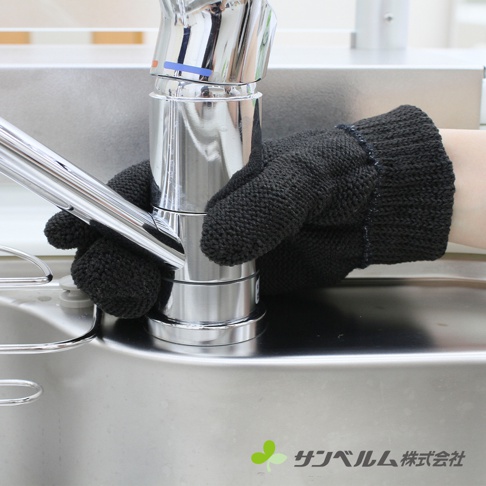 一隻戴著黑色針織材質萬用清潔手套的手，正清潔著銀色金屬水龍頭，水龍頭下方是金屬水槽。