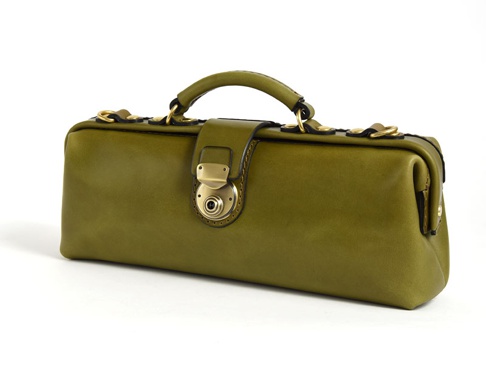 橄欖綠皮革製成的橫長形手提包，帶有復古風格的黃銅鎖扣和提把，兩側有 D 型環可連接肩帶。