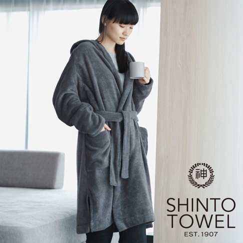 一名女子身穿一件深灰色連帽浴袍，腰間繫有同材質的腰帶，浴袍上有兩個口袋。