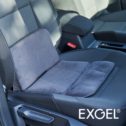 灰色麂皮材質的行動折疊腰靠坐墊，置於汽車座椅上，可見坐墊上有細小透氣孔，腰靠部分呈弧形，整體設計貼合人體工學。