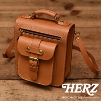 職人手作皮革立體口袋兩用單肩包，採用棕色皮革製成，設有頂部提把、可拆卸肩帶、拉鍊主隔層及翻蓋前袋，搭配黃銅扣件與撞色縫線。