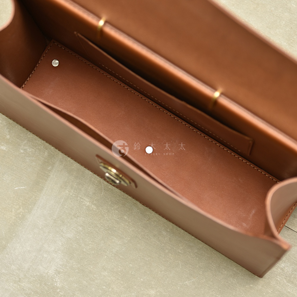 職人手作皮革Organ兩用商務公事包，展示其內部結構，為棕褐色皮革材質，包含多個隔層與金屬旋轉鎖扣，設計簡潔實用。
