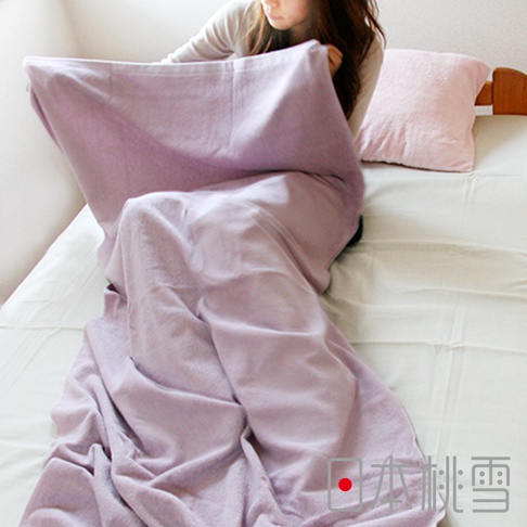 一位女性蓋著一條淺紫色、柔軟的超大浴巾，浴巾材質看起來是絨毛。