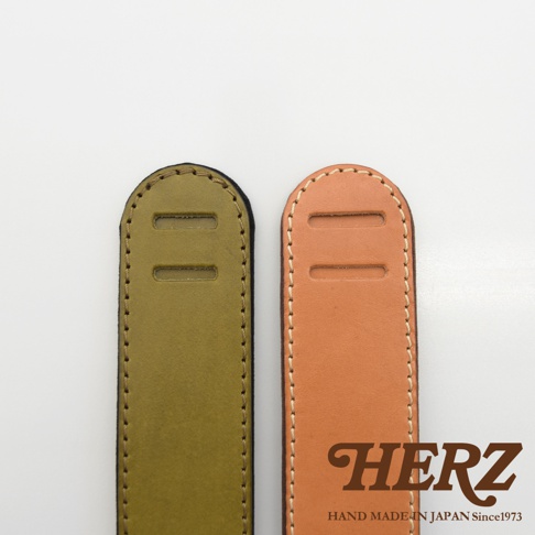 職人手作皮革Big肩墊，展示橄欖綠與原色皮革兩種顏色，兩者皆為牛皮材質，帶有雙排縫線和兩個長形孔洞。