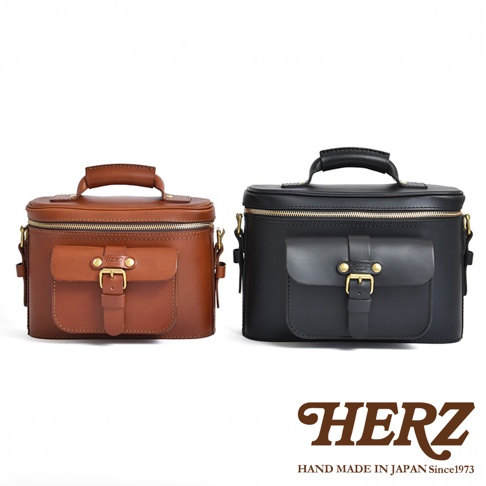 兩個HERZ品牌手作皮革相機包，一個為咖啡色，一個為黑色，皆帶有翻蓋式前袋與金屬扣環。
