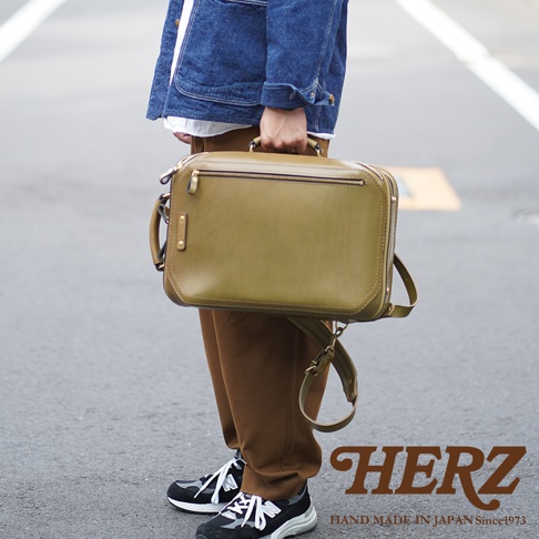 橄欖綠皮革兩用商務後背包，方形設計，雙拉鍊開口，頂部附手提把，可拆卸肩帶，簡約風格。